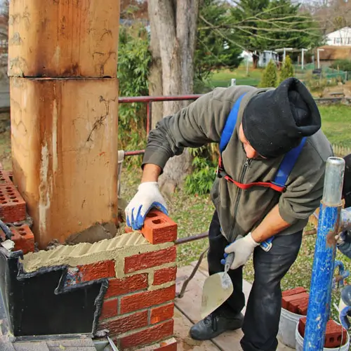 майстор изгражда тухлен комин